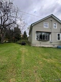 view of side of home with a yard