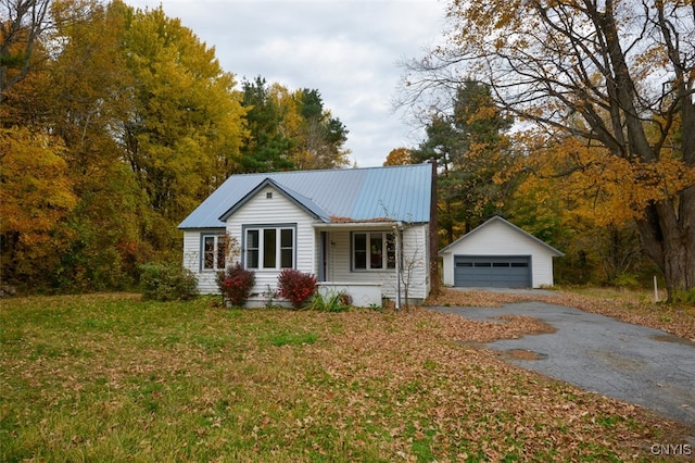 view of front of house featuring a front lawn, an outbuilding, and a garage