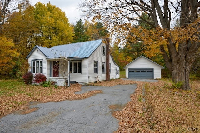 view of front of house featuring a garage and an outbuilding