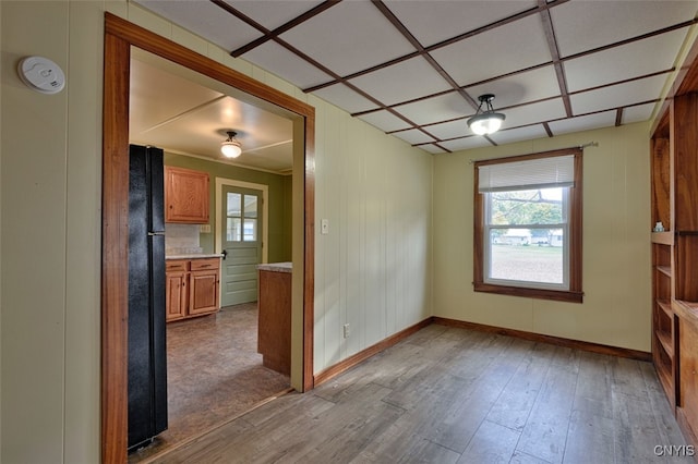 unfurnished dining area featuring light hardwood / wood-style flooring and wood walls