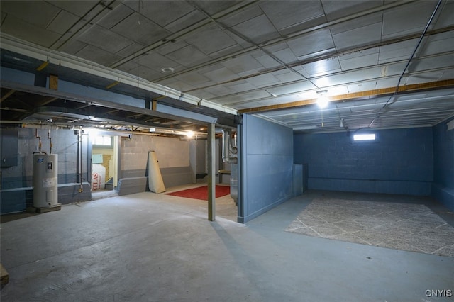 basement featuring electric water heater, a healthy amount of sunlight, and electric panel