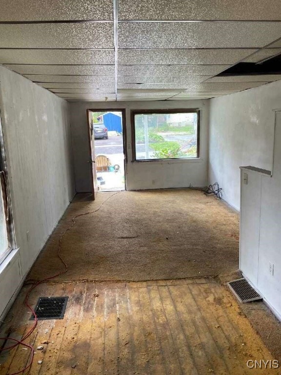 empty room with hardwood / wood-style flooring and a drop ceiling