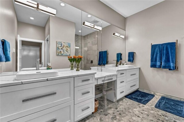 bathroom with vanity and tiled shower