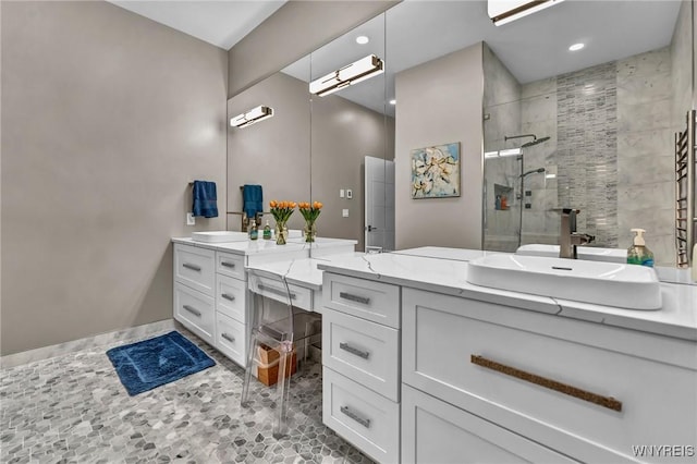 bathroom featuring a shower with door and vanity