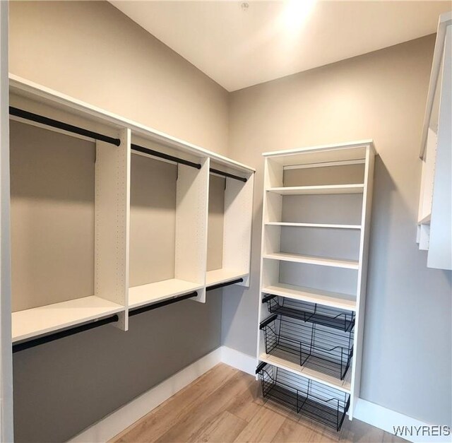 walk in closet with light hardwood / wood-style flooring