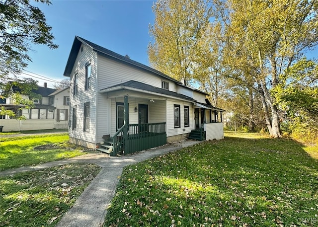 view of side of property featuring covered porch and a lawn