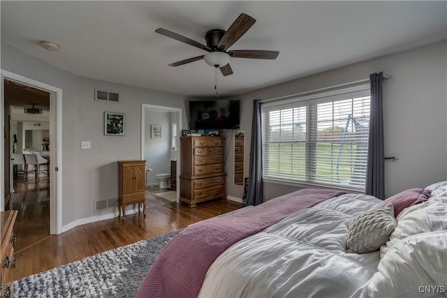 bedroom with ceiling fan, dark hardwood / wood-style flooring, and ensuite bath