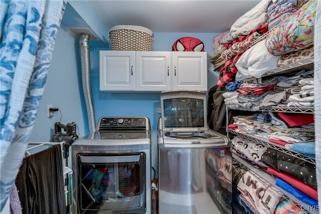 laundry room with washer and dryer and cabinets