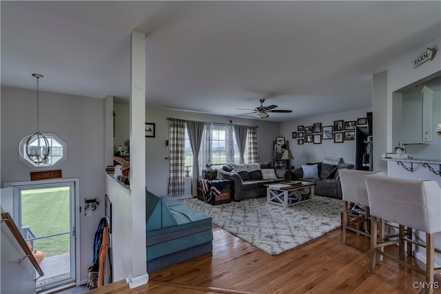 living room featuring hardwood / wood-style flooring and ceiling fan with notable chandelier