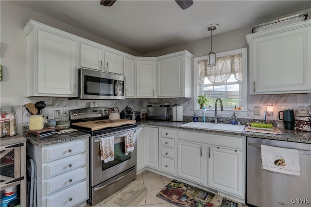 kitchen featuring sink, light tile patterned flooring, white cabinetry, stainless steel appliances, and decorative backsplash