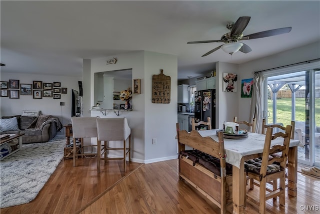 dining area with ceiling fan and light wood-type flooring