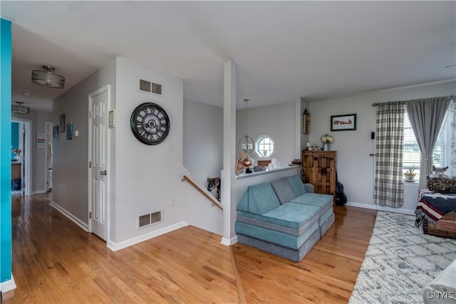 living room with light hardwood / wood-style floors and a chandelier