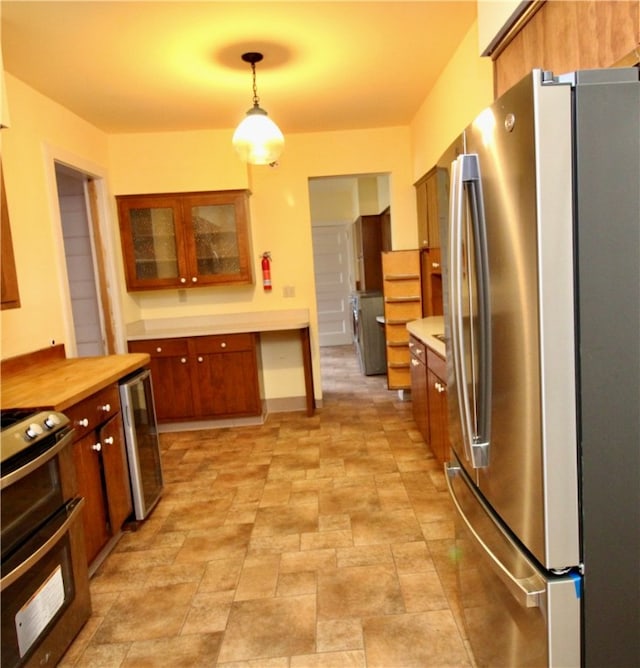 kitchen featuring butcher block counters, hanging light fixtures, beverage cooler, stainless steel refrigerator, and electric stove