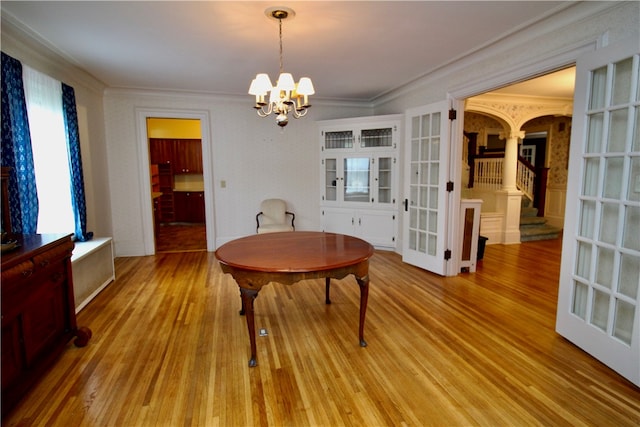 dining room with an inviting chandelier, crown molding, and light hardwood / wood-style floors