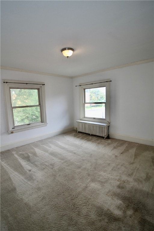 spare room with ornamental molding, carpet, and radiator heating unit