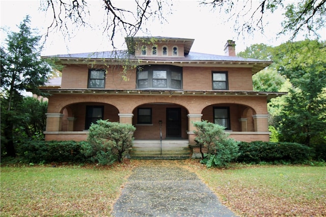 view of front of house with a front yard and covered porch