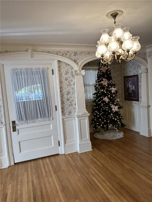 interior space featuring a wealth of natural light, hardwood / wood-style floors, and a notable chandelier