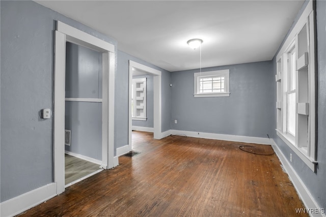 empty room with dark hardwood / wood-style flooring