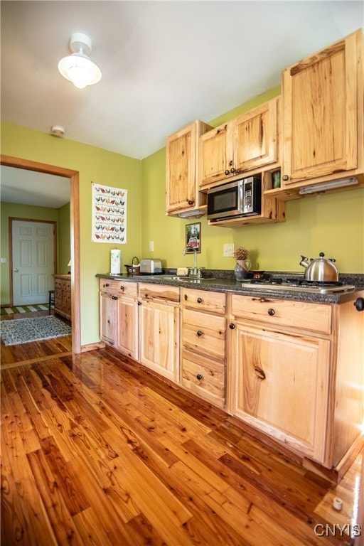 kitchen featuring dark wood-type flooring, appliances with stainless steel finishes, sink, and light brown cabinets