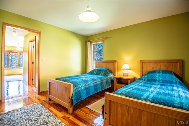 bedroom with multiple windows and wood-type flooring