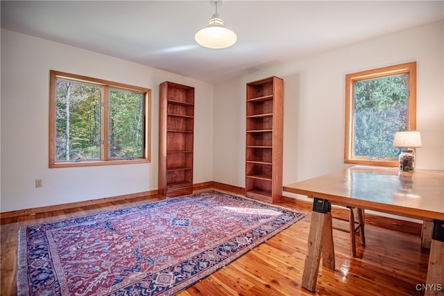 office featuring wood-type flooring and built in shelves