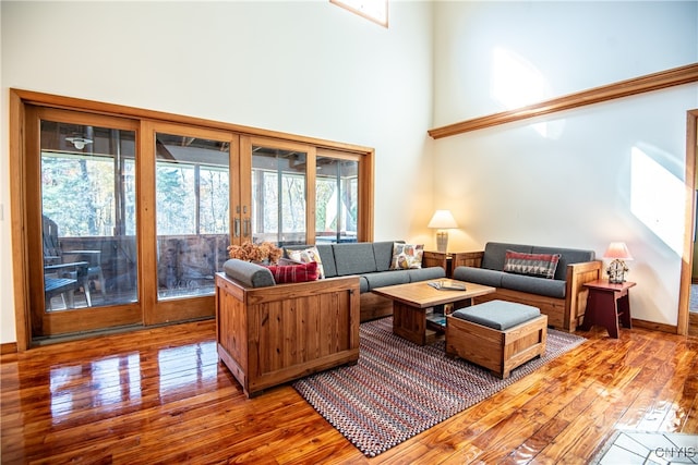 living room with hardwood / wood-style flooring and a towering ceiling