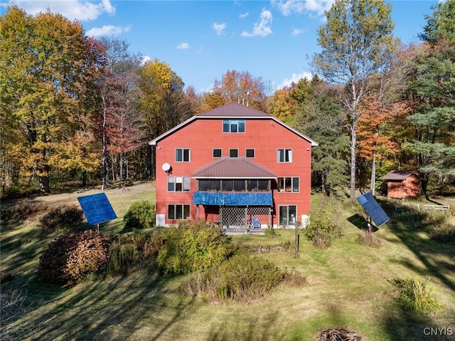 back of property with a storage shed and a lawn