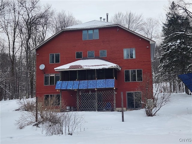 view of snow covered back of property