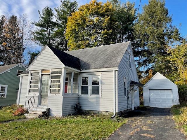 view of front of property with a front yard, an outbuilding, and a garage