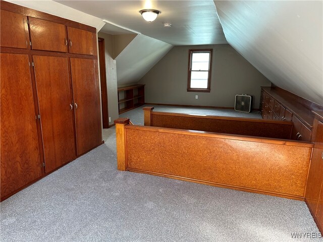 interior space with lofted ceiling, light carpet, and a closet