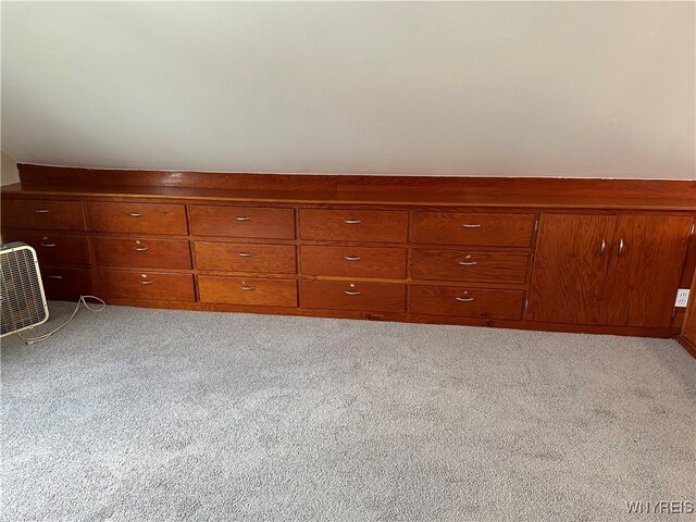 unfurnished bedroom featuring wooden walls and light carpet