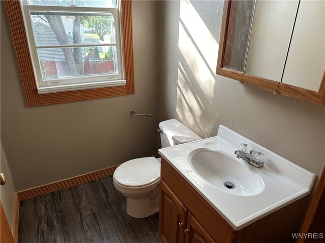 bathroom with vanity, toilet, and hardwood / wood-style floors