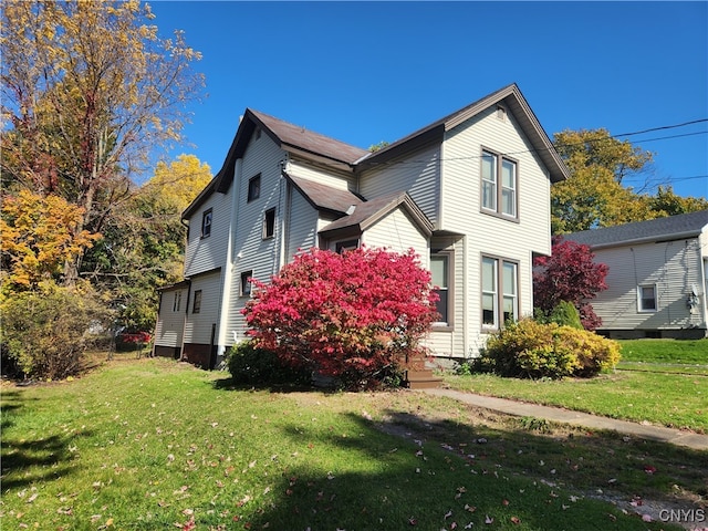 view of side of home with a yard