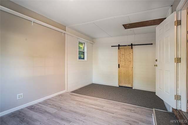 spare room featuring hardwood / wood-style floors and a barn door