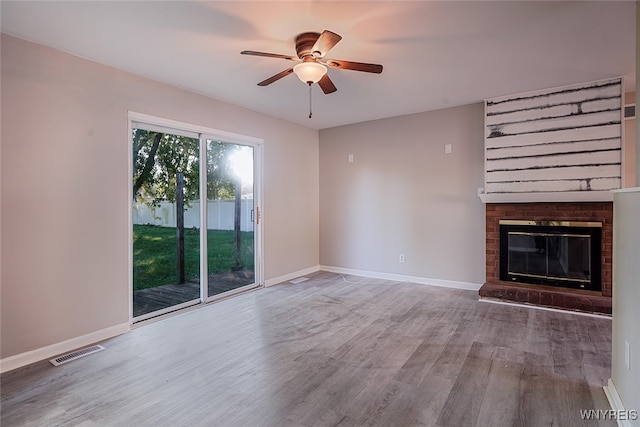 unfurnished living room featuring a fireplace, wood-type flooring, and ceiling fan