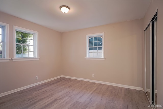 unfurnished bedroom with light hardwood / wood-style floors and a closet