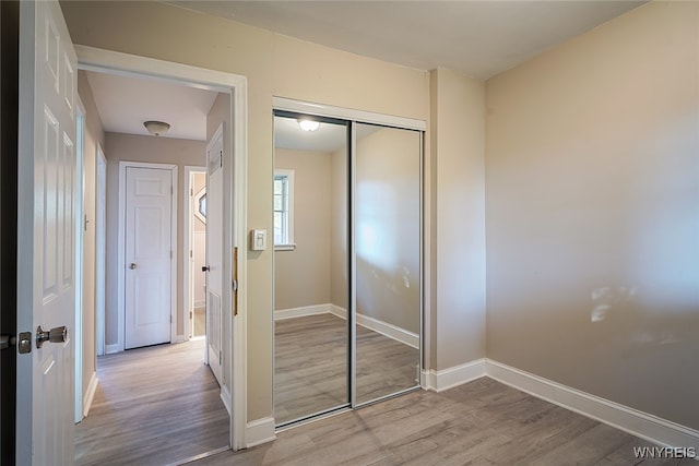 unfurnished bedroom featuring a closet and light wood-type flooring