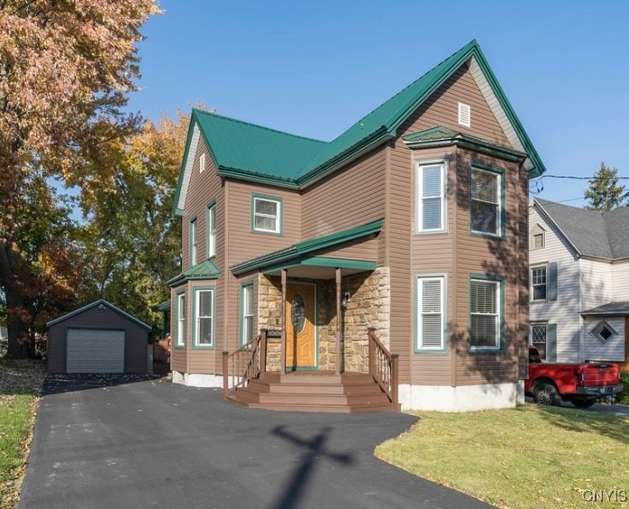 view of front of house with a garage, a front lawn, and an outdoor structure