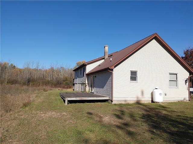 view of side of property with a wooden deck and a lawn