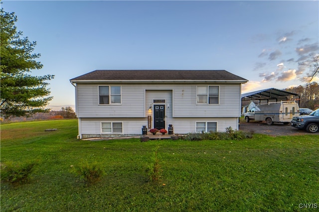 bi-level home featuring a lawn and a carport