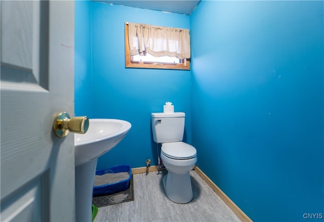 bathroom with toilet and hardwood / wood-style flooring