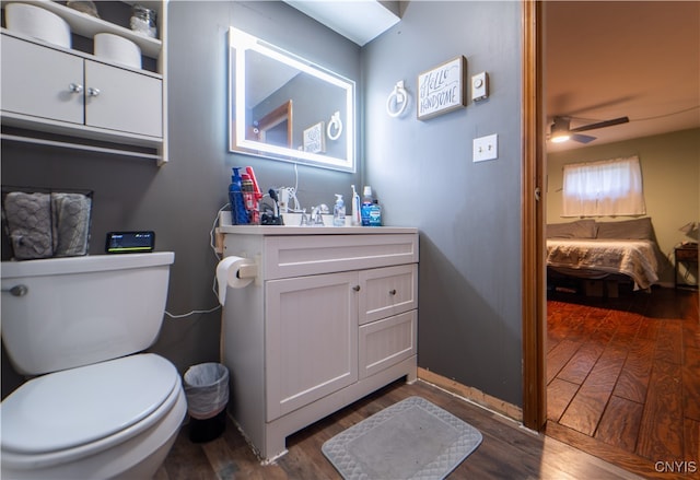 bathroom with vanity, hardwood / wood-style flooring, toilet, and ceiling fan