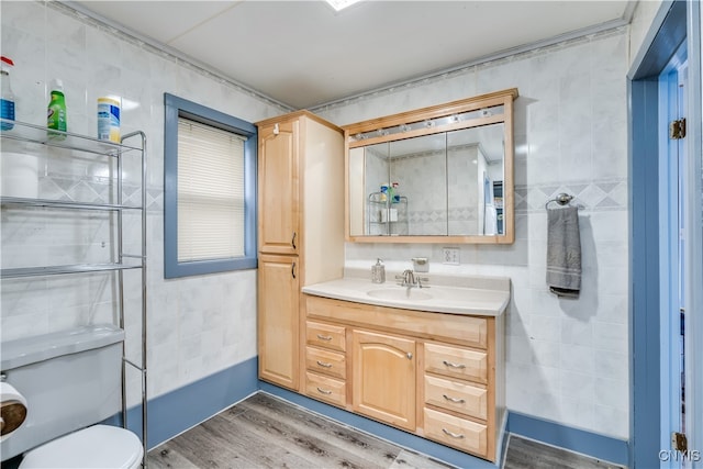 bathroom featuring tile walls, vanity, hardwood / wood-style flooring, and toilet