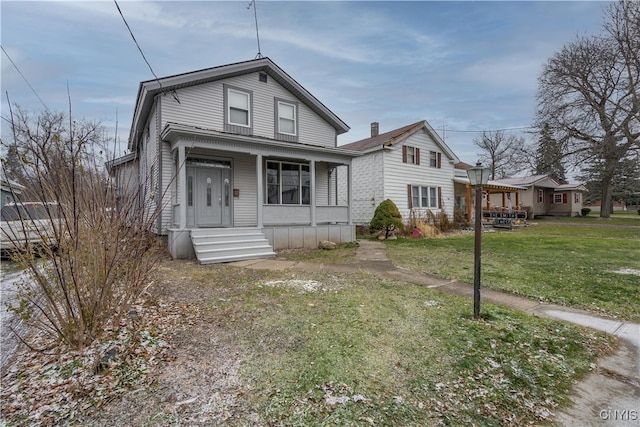 bungalow-style home with a front yard