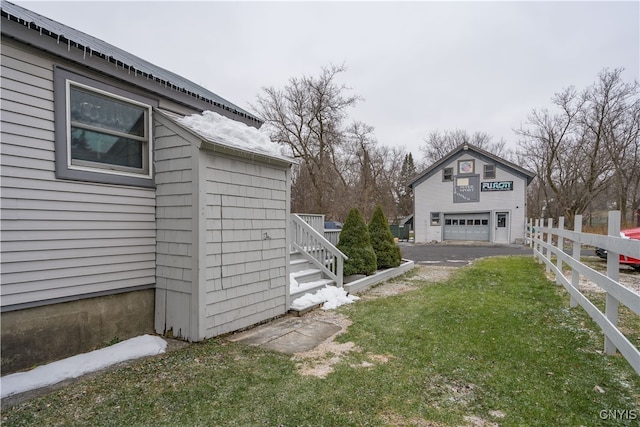 view of yard with a garage and an outbuilding