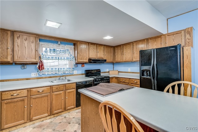 kitchen with black appliances, ventilation hood, and sink