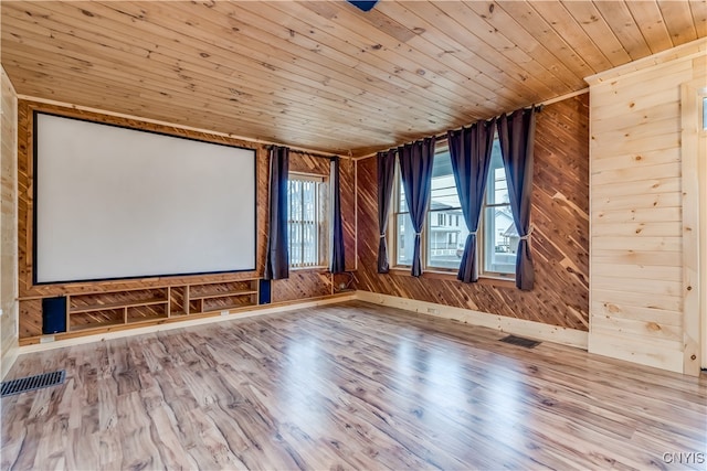 cinema with light hardwood / wood-style flooring, wood walls, and wood ceiling