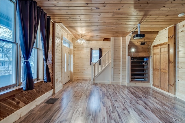 entryway featuring wood walls, wooden ceiling, and plenty of natural light