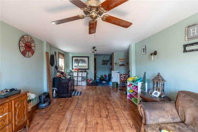 living room with ceiling fan and wood finished floors