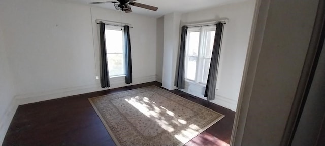 empty room featuring dark wood-type flooring and ceiling fan